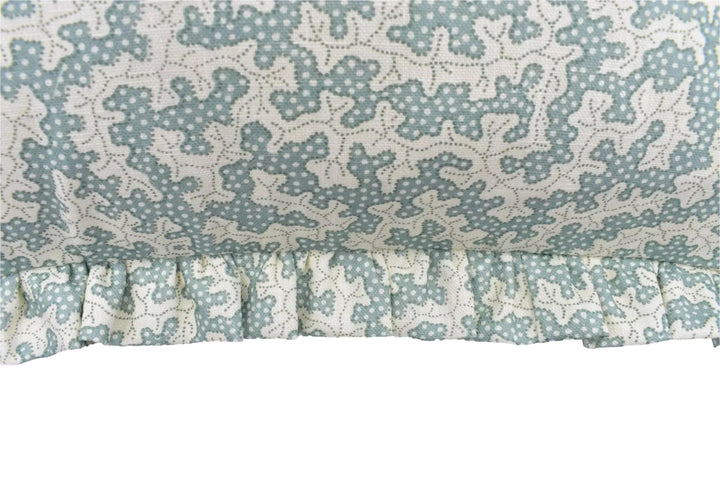 a close-up view of a fabric with a floral pattern, featuring a ruffled trim.