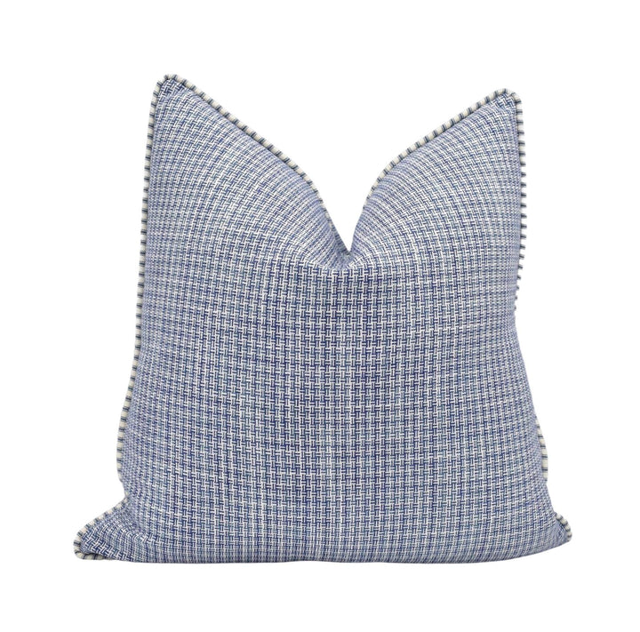 A blue and white checkered throw pillow with a pointed top and a scalloped edge.