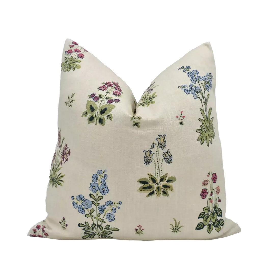 a decorative pillow with a floral pattern on a cream-colored background.