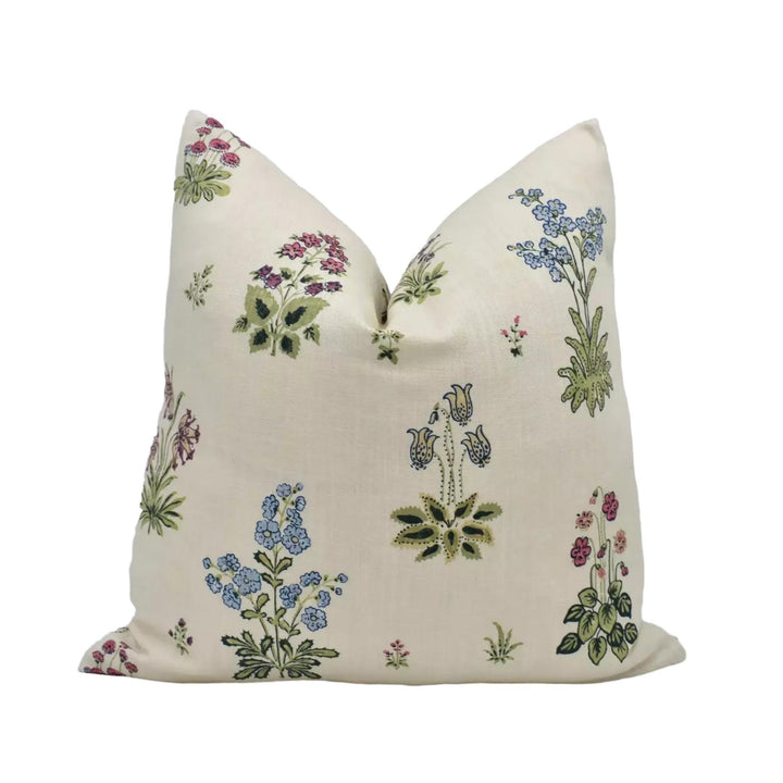 a decorative pillow with a floral pattern on a cream-colored background.