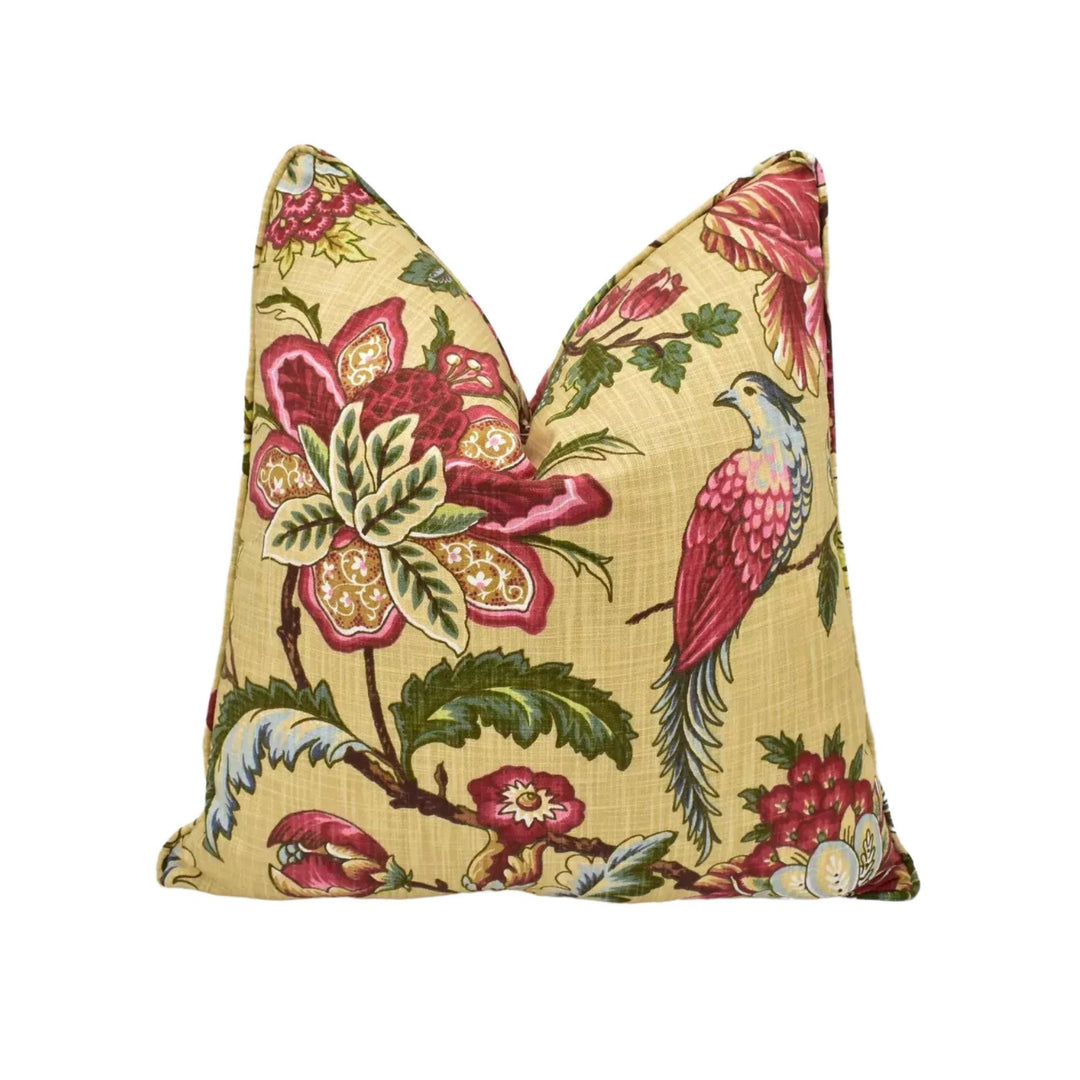 a decorative pillow with a floral pattern, including a large pink flower and a bird.