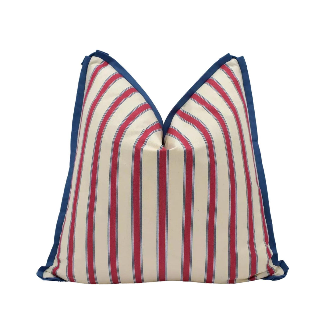 A pillow with a striped pattern in red, white, and blue colors.