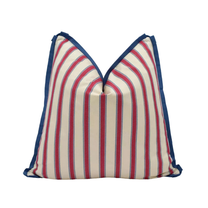 A pillow with a striped pattern in red, white, and blue colors.