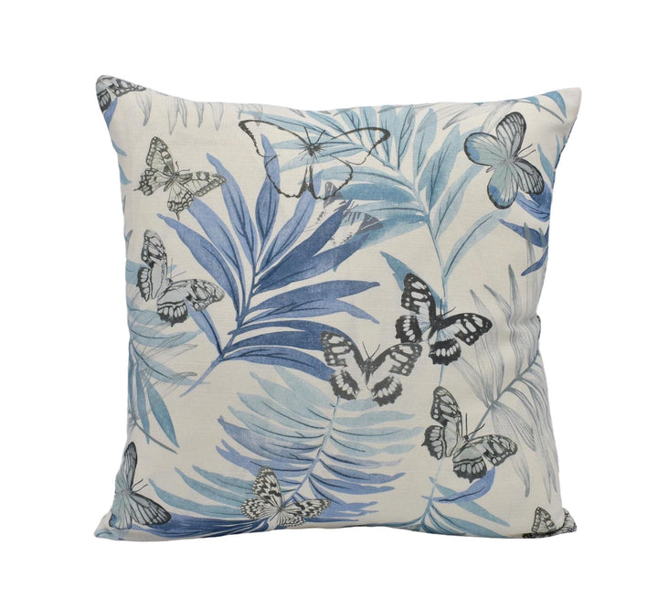a square throw pillow with a blue and white tropical leaf pattern and multiple butterflies.