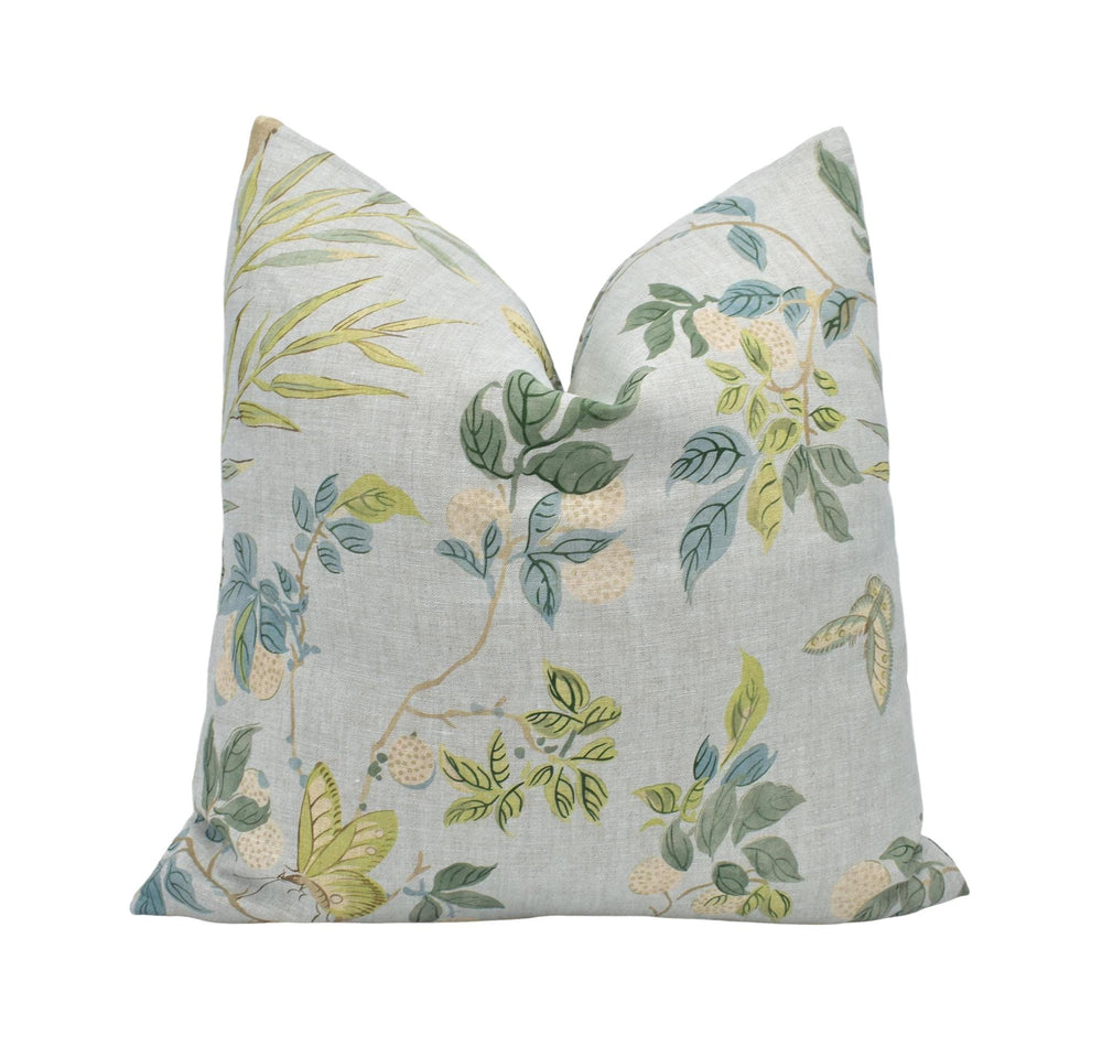 a white pillow with a green and yellow floral pattern