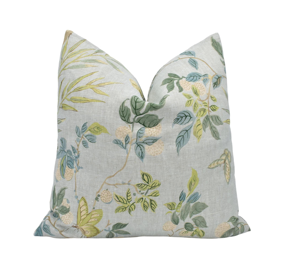 a white pillow with a green and yellow floral pattern