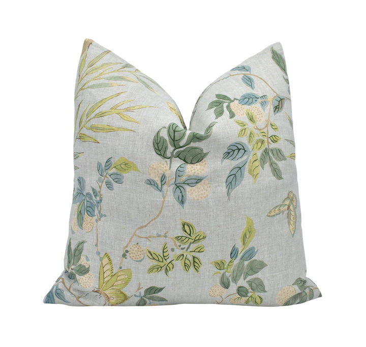 a white pillow with a green and yellow floral pattern