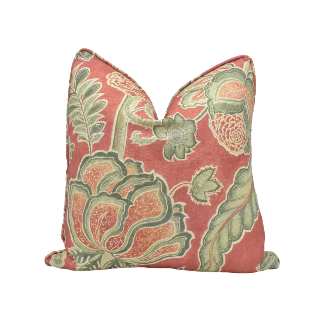 a decorative pillow with a floral pattern in shades of pink and green.