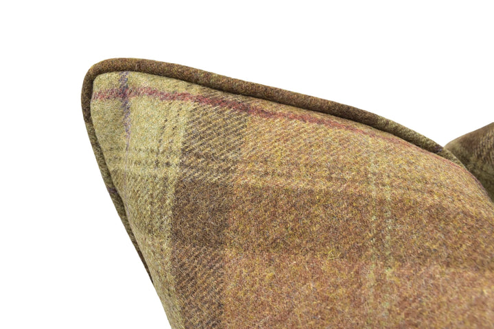 A close-up view of a brown plaid fabric, possibly a pillow or cushion, with a distinctive curved edge.
