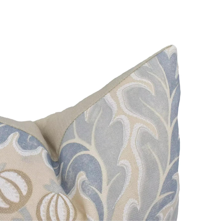 A close-up view of a decorative pillow with a floral pattern in shades of blue and beige.