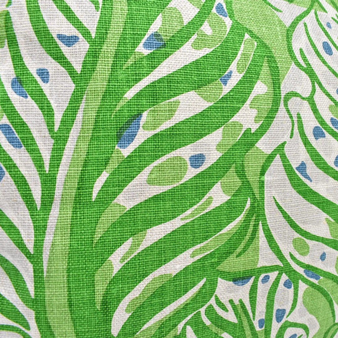 a close-up view of a fabric with a green and white leaf pattern. The fabric appears to be a type of textile, possibly a piece of clothing or a textile product. The leaf pattern is the main focus of the image, with the fabric&