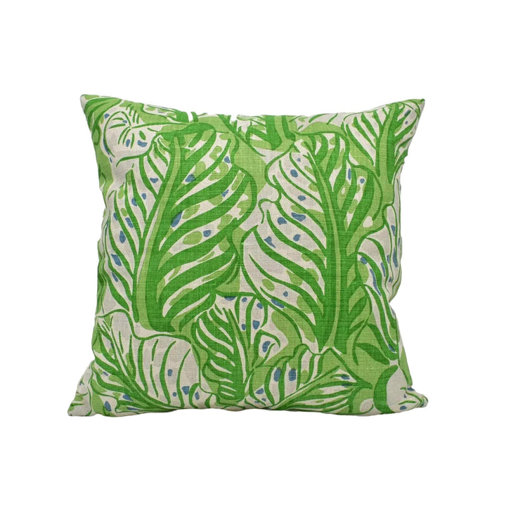 A square throw pillow with a green leaf pattern.
