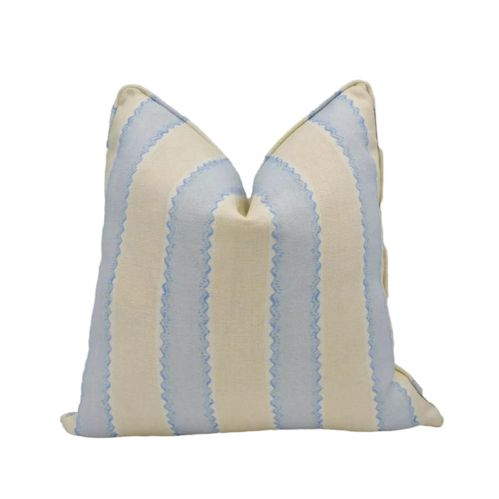 A pillow with a striped pattern in shades of blue and beige.