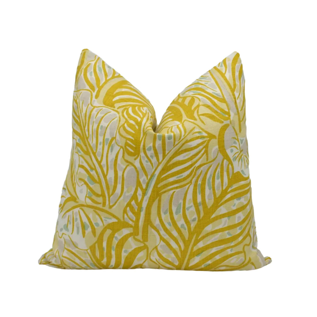 A yellow and white patterned pillow with a tropical leaf design.