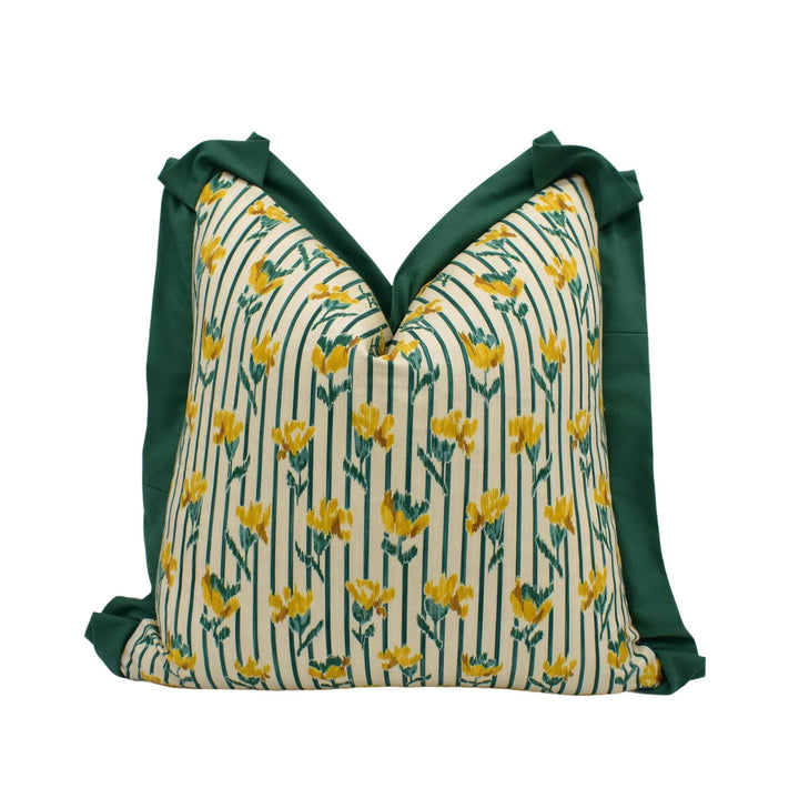 A decorative pillow with a floral pattern in shades of green and yellow.
