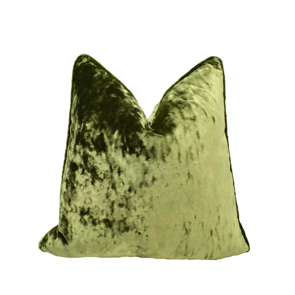 A green velvet pillow with a textured, speckled appearance.