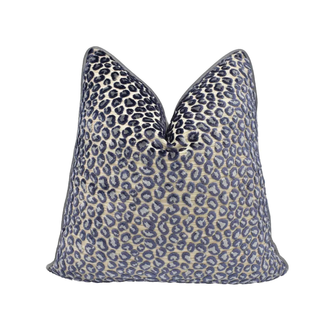A leopard print throw pillow with a dark blue and beige pattern.