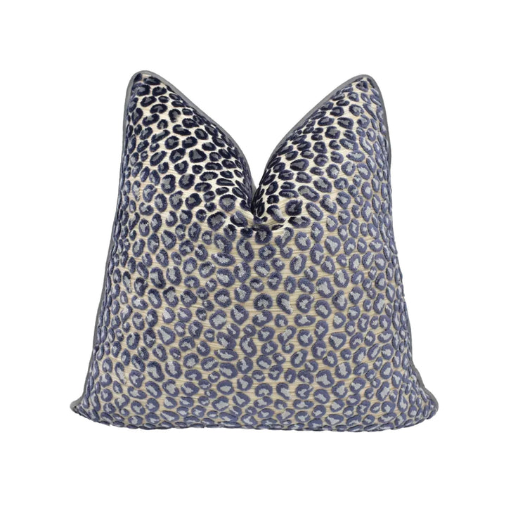 A leopard print throw pillow with a dark blue and beige pattern.
