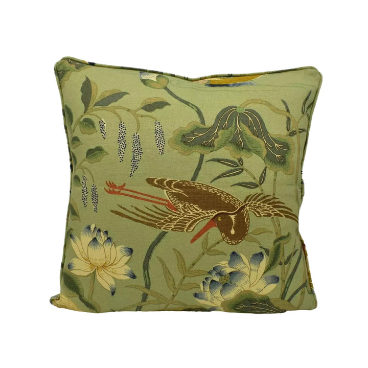 A square throw pillow with a vibrant green fabric featuring a detailed illustration of a bird, flowers, and leaves.