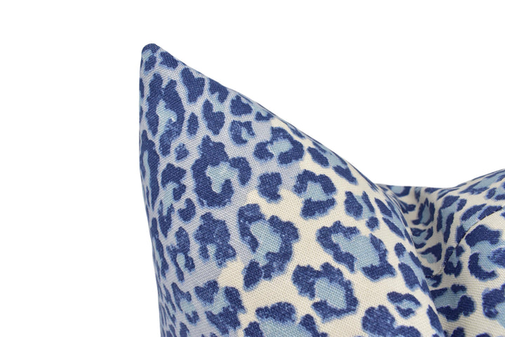 a blue and white animal print pillow on a white background