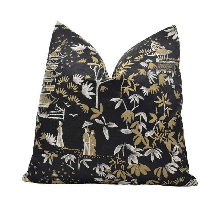 a black pillow with a gold and white pattern