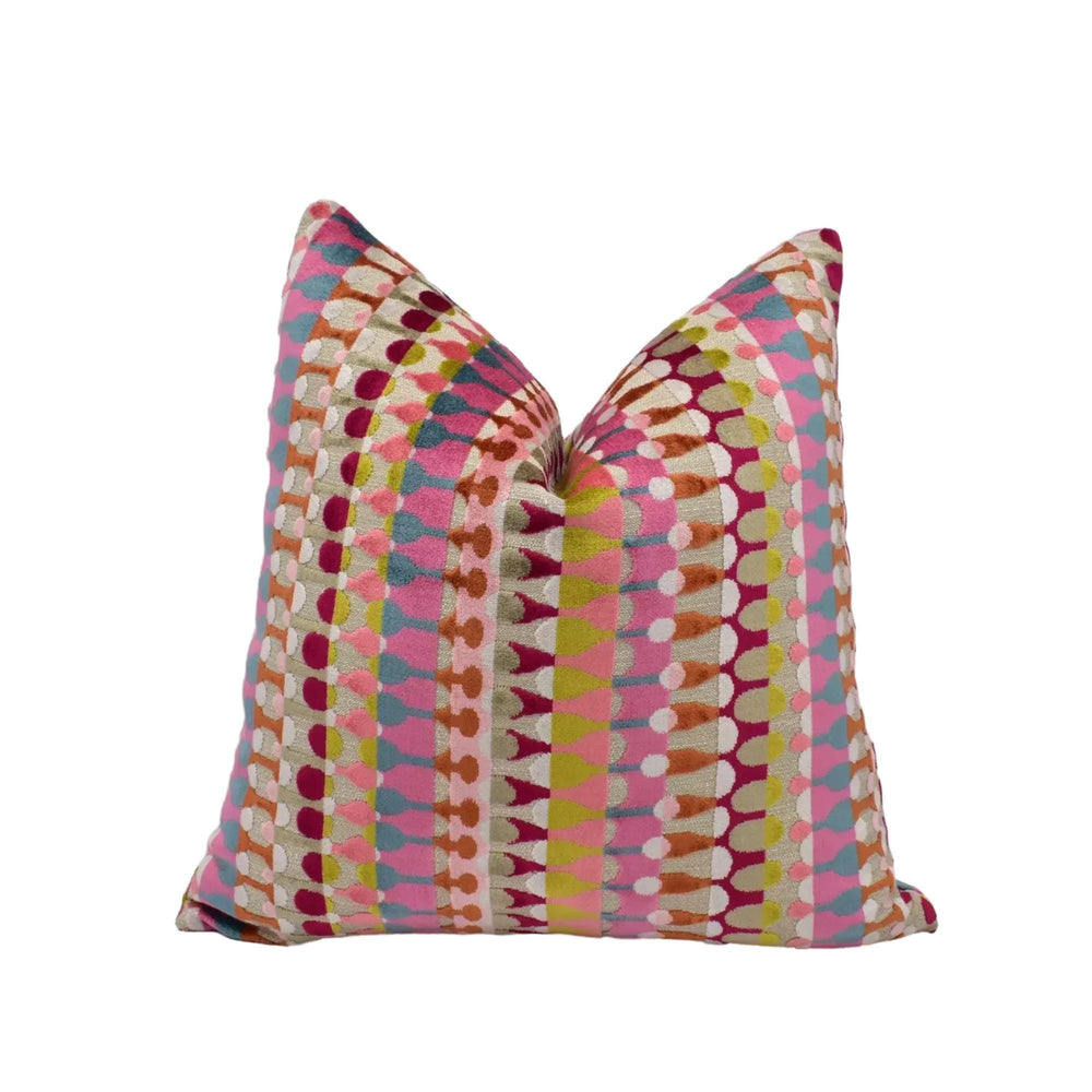 a colorful, patterned throw pillow with a vibrant design of stripes and dots in various shades of pink, orange, yellow, and green.
