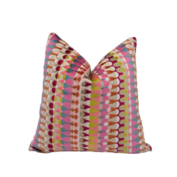 a colorful, patterned throw pillow with a vibrant design of stripes and dots in various shades of pink, orange, yellow, and green.