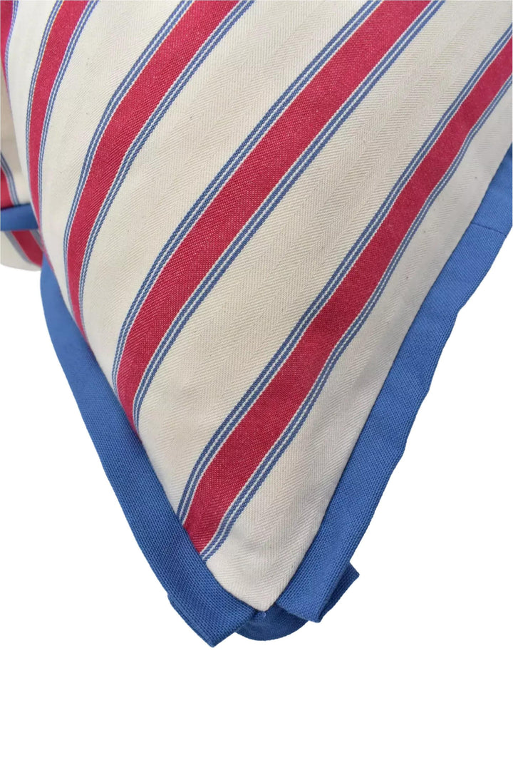 a close-up view of a pillow with a striped pattern in red, white, and blue colors.
