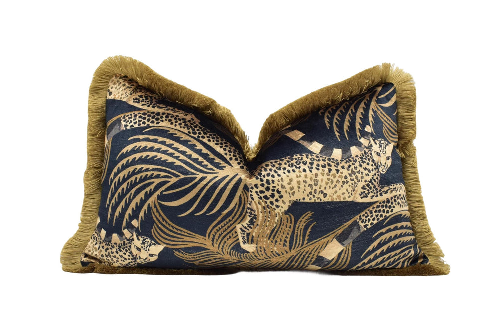 A decorative throw pillow with a blue and gold pattern featuring a leopard and palm leaves.