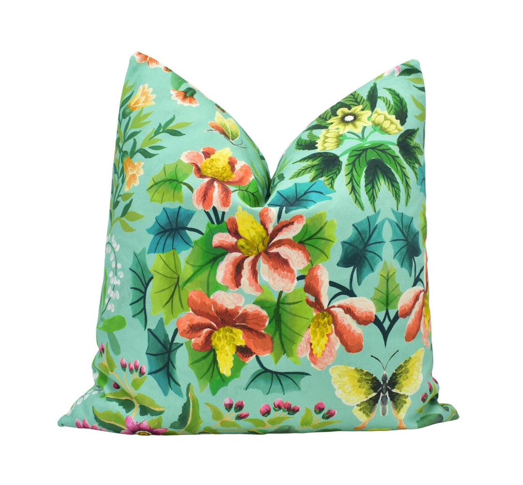 a blue pillow with flowers and butterflies on it