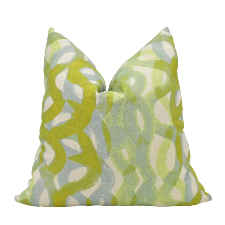 A pillow with a vibrant, abstract pattern in shades of green and yellow.