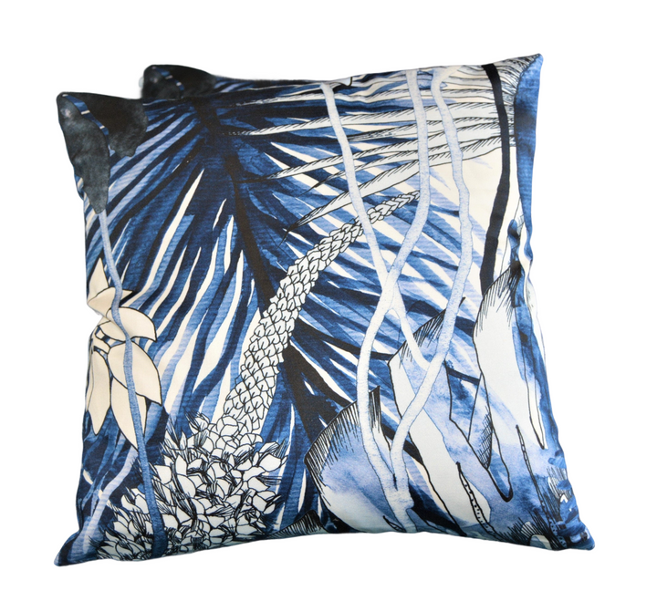 a blue and white pillow with palm trees on it