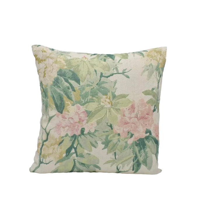 A square throw pillow with a floral print in shades of green and pink.