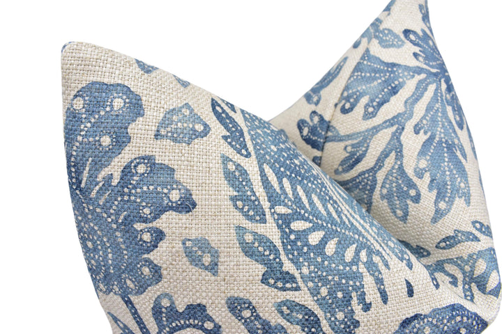 a close up of a blue and white pillow on a white background