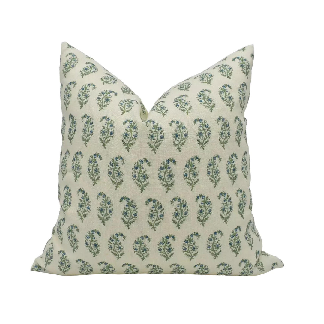A decorative pillow with a repeating pattern of green and white flowers or leaves.