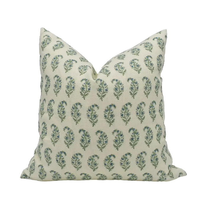 A decorative pillow with a repeating pattern of green and white flowers or leaves.