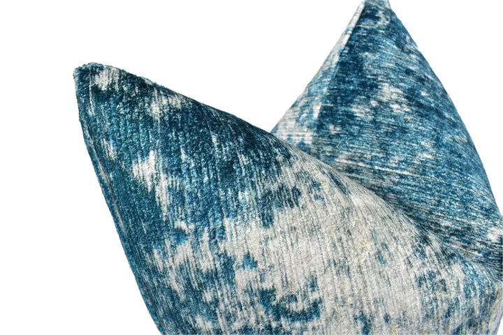 a close-up view of a textured fabric, possibly a pillow or cushion, with a blue and white pattern.