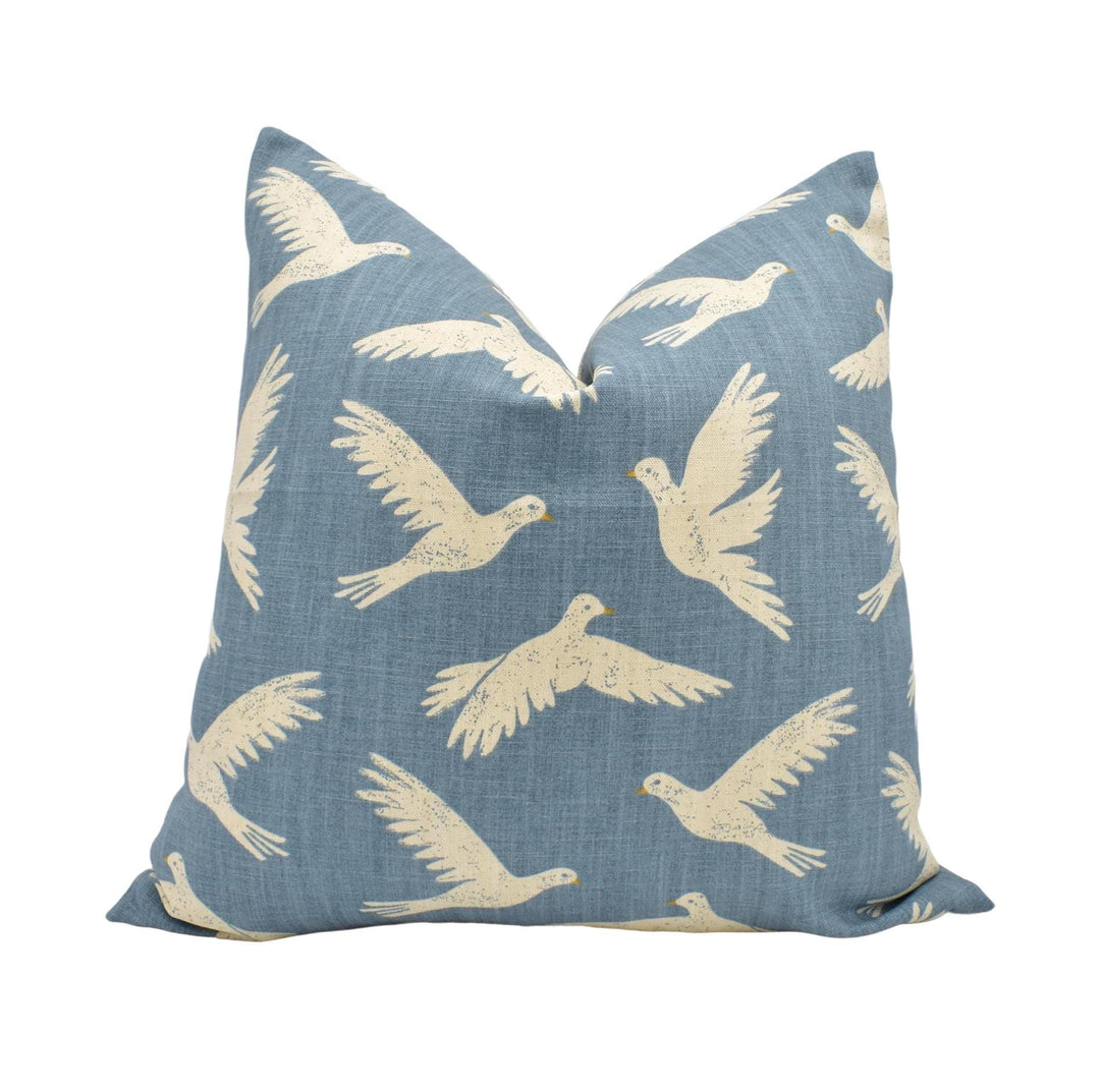 a blue pillow with white birds on it