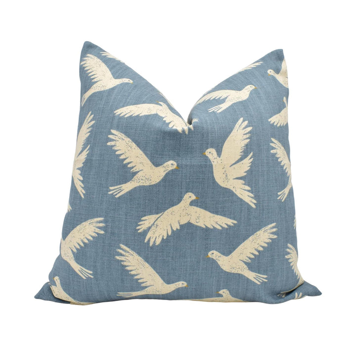 a blue pillow with white birds on it