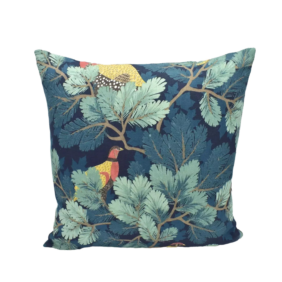 A square throw pillow with a vibrant, nature-inspired pattern of green leaves and branches, along with a bird in flight.