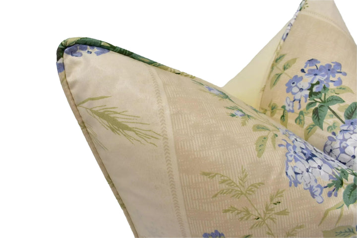 A close-up view of a decorative pillow with a floral pattern in shades of green and blue.