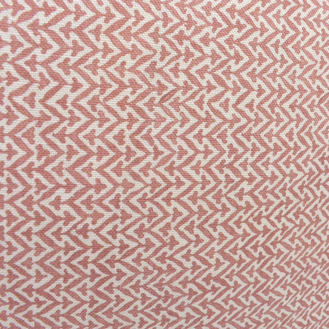 a close-up view of a fabric with a repeating pattern of pink and white zigzag lines.