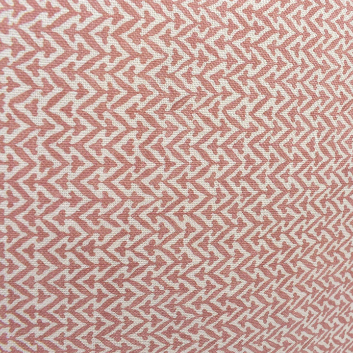 a close-up view of a fabric with a repeating pattern of pink and white zigzag lines.