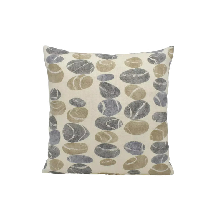 A square throw pillow with a repeating pattern of gray and brown stones or pebbles on a cream-colored background.