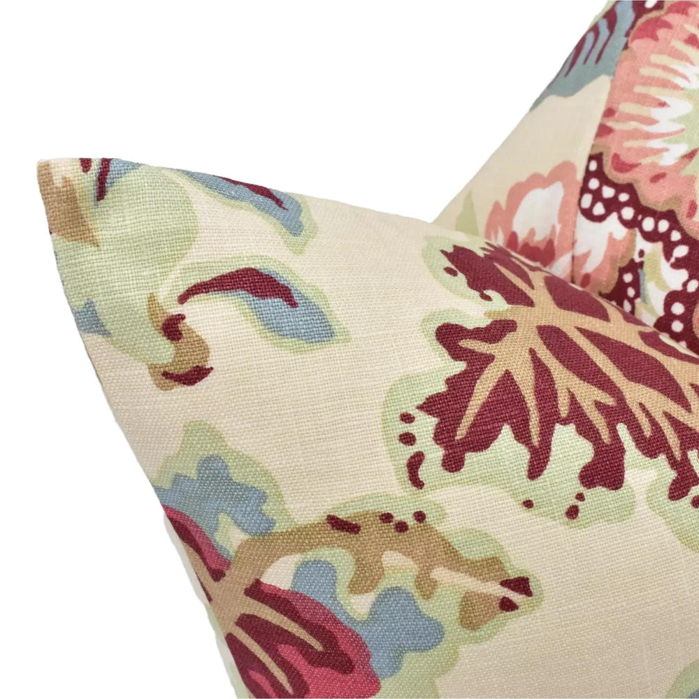 A close-up view of a decorative pillow with a floral pattern in shades of pink, green, and blue.
