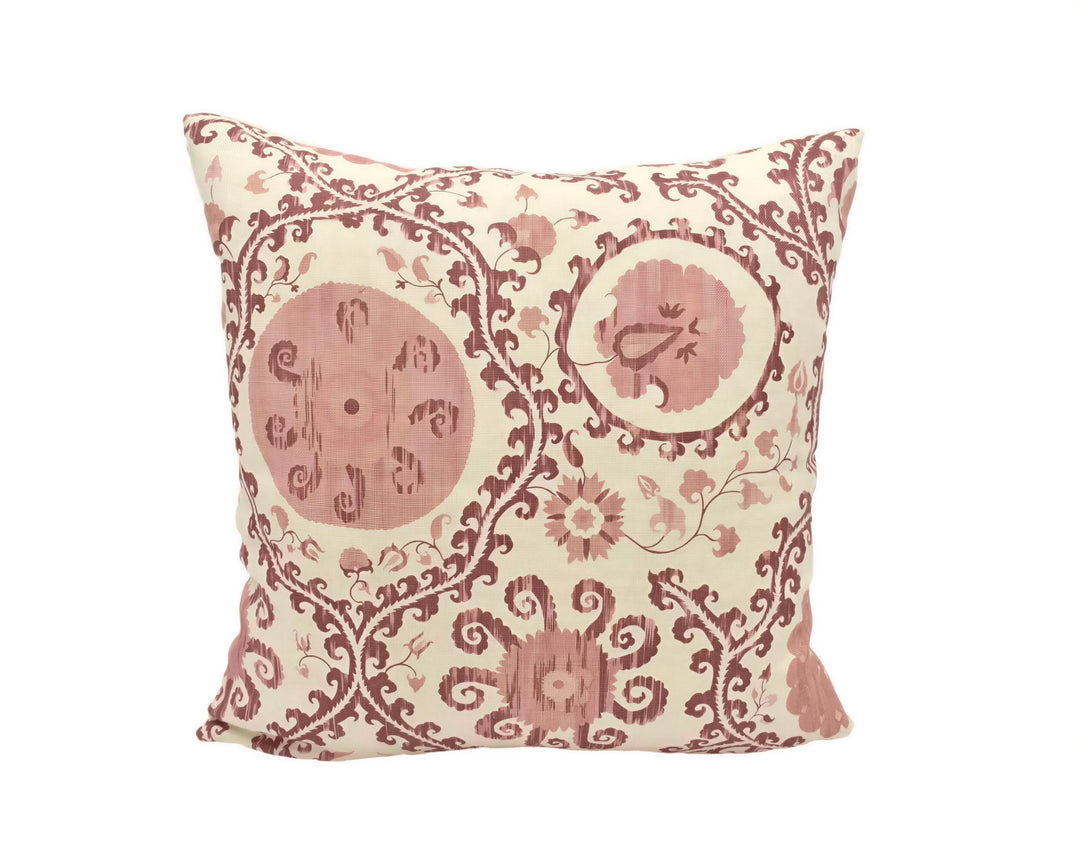 A decorative throw pillow with a floral pattern in shades of pink and white.