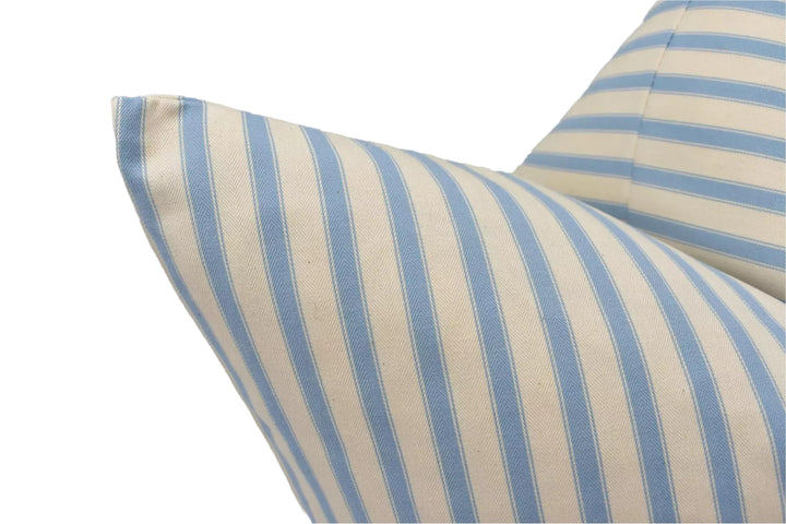 A close-up view of a pillow with blue and white striped fabric, featuring a pattern of vertical stripes.