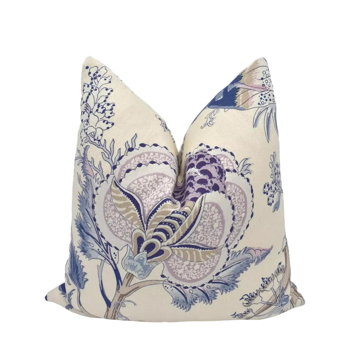 A decorative pillow with a floral pattern in shades of blue and purple.