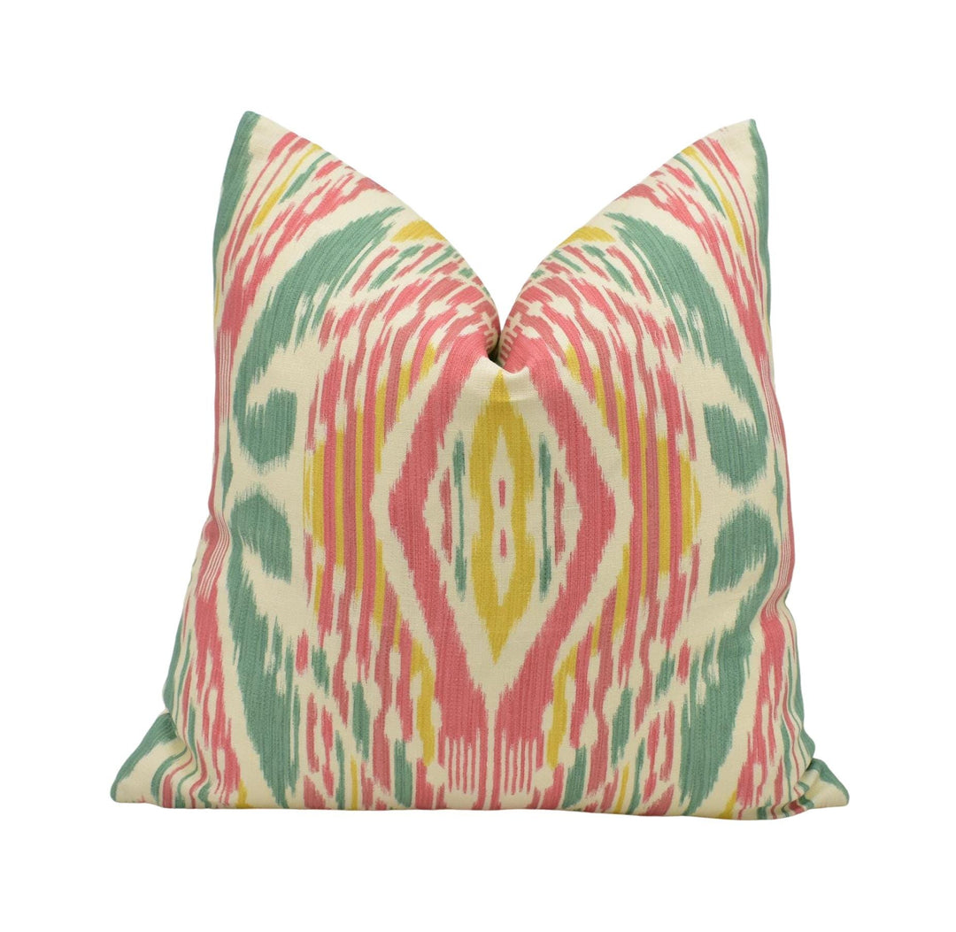 A colorful throw pillow with a vibrant, abstract pattern in shades of pink, green, and yellow.