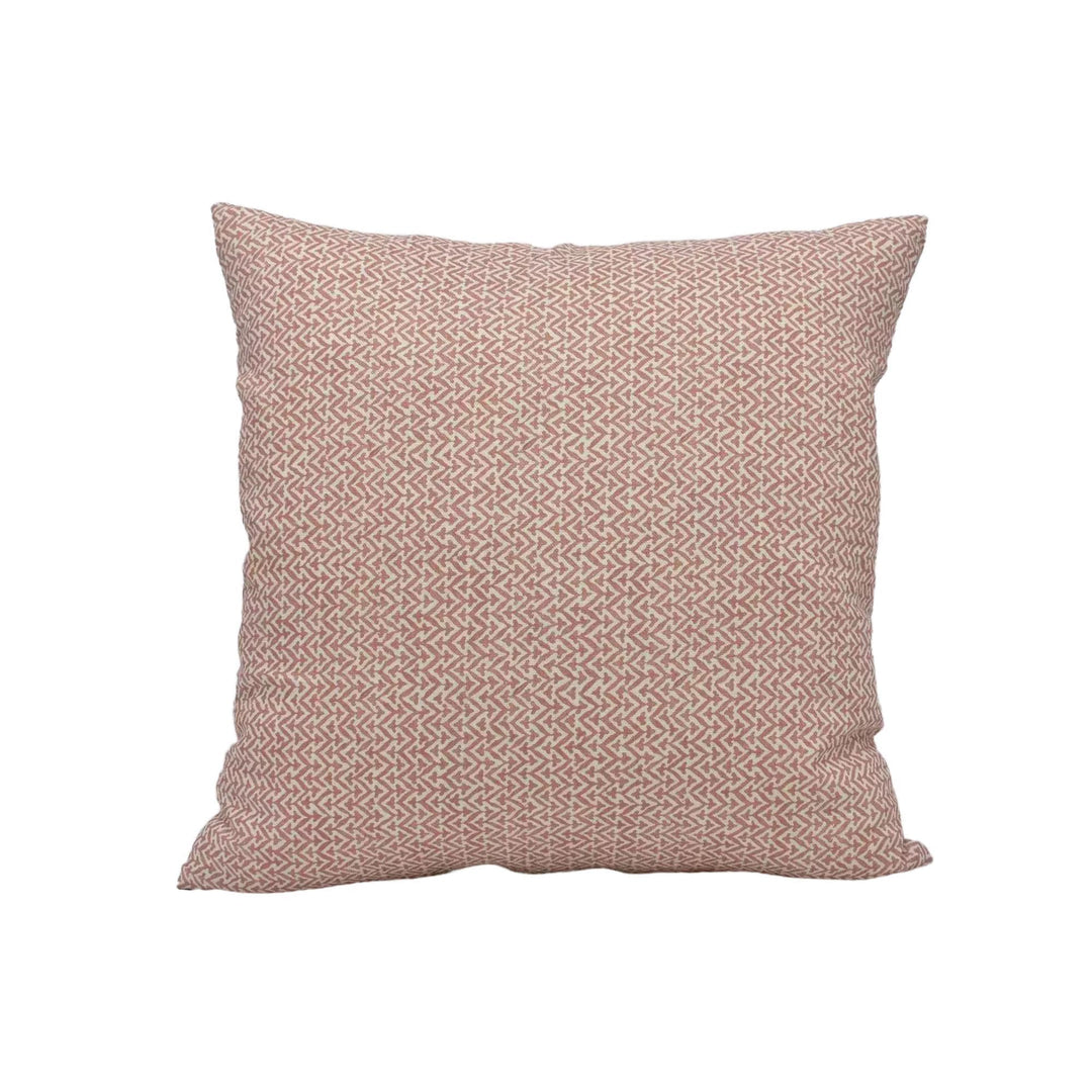 A single square pillow with a repeating pattern of pink and white geometric shapes.